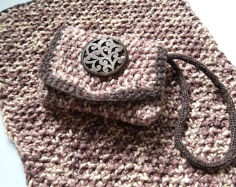 May include: A brown and cream crocheted bag with a brown handle and a decorative metal button. The bag has a smaller pocket on the front.