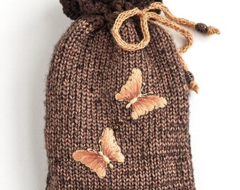 May include: A brown knitted drawstring bag with a crocheted top and two embroidered butterflies.