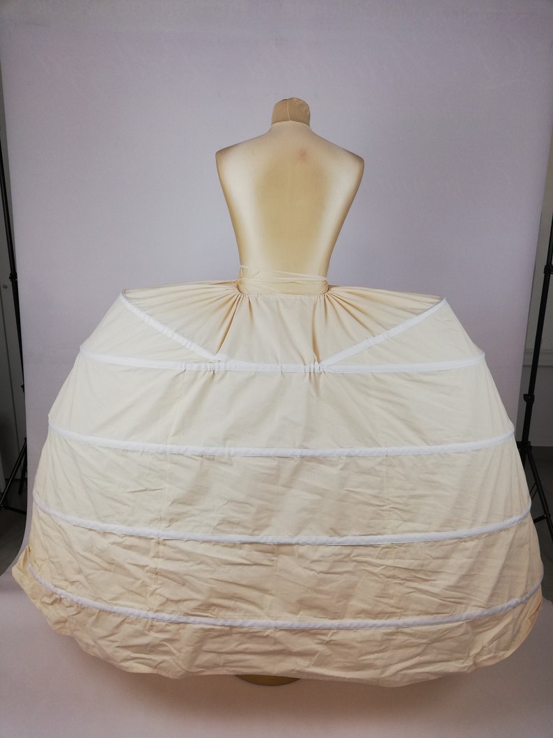 May include: A white petticoat with multiple layers and a ruffled edge. The petticoat is designed to create a full, voluminous skirt.