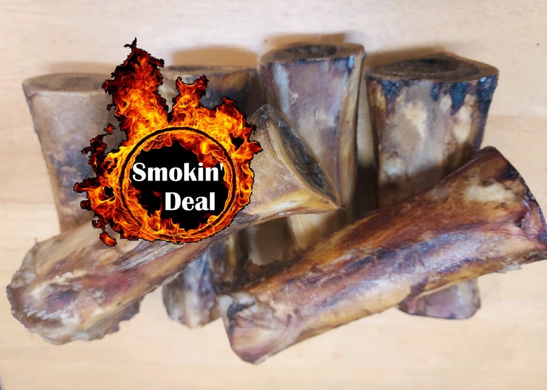 May include: Several smoked beef bones, displaying a range of forms and dimensions. The bones are a deep brown with blackened edges. The image features a graphic with the words "Smokin' Deal" encircled by flames.
