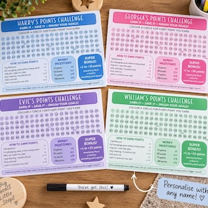 May include: Four rectangular paper points challenge charts in blue, pink, purple, and green. Each chart features numbered circles from 1 to 100, sections for earning points, money milestones in pounds, and a super bonus area. A black marker is included.