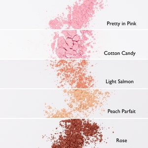 May include: Five different shades of blush powder, from light pink to deep red, are shown in a row. The shades are labeled "Pretty in Pink", "Cotton Candy", "Light Salmon", "Peach Parfait", and "Rose".