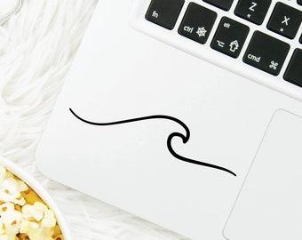May include: A white laptop with a black keyboard and a black wave sticker on the top of the laptop. The laptop is on a white fluffy surface with a bowl of popcorn and a clear glass bottle with a pink lid and a pink straw.