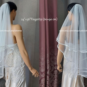 Puede incluir: Un velo de novia de tul blanco de dos niveles con borde de cinta de sat&eacute;n, que mide 60 cm y 90 cm de largo. El velo se muestra en un maniqu&iacute; con un vestido de encaje blanco, con el texto 24"+36"Fingertip (60+90 cm) y una URL.