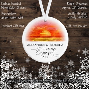 May include: A white round porcelain ornament with a watercolor sunset scene and the text "ALEXANDER & REBECCA 10.15.2021 Engaged". The ornament is 2.8 inches in diameter and comes with a ribbon and gift box.