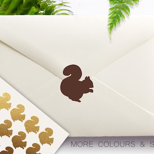May include: A brown squirrel sticker on a cream-colored envelope. A sheet of gold glitter squirrel stickers is in the lower left corner. The text "MORE COLOURS & SIZES" is at the bottom.