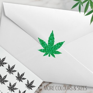 May include: White envelope with a green glitter cannabis leaf. A sheet of stickers with black glitter cannabis leaves is next to the envelope. The text "MORE COLOURS & SIZES" is at the bottom.