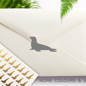 May include: An off-white envelope with a gray seal silhouette and a sheet of gold bird stickers. The text "MORE COLOURS & SIZES" is visible. The logo "Confetti Barn" is in the upper left corner.