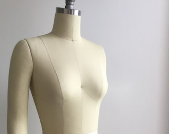 Puede incluir: Un maniquí de costura beige con un hombro plegable, etiquetado "Atelier Stand Professional Collapsible Shoulder 10".
