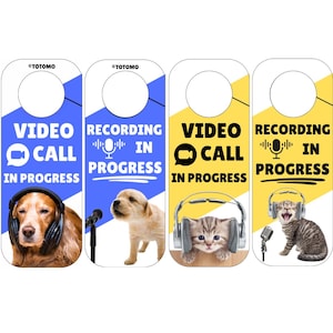 Puede incluir: Cuatro colgadores de puerta con los textos "VIDEO CALL IN PROGRESS" y "RECORDING IN PROGRESS". Cada colgador presenta un animal diferente con auriculares: un perro, un cachorro, un gatito y un gato.