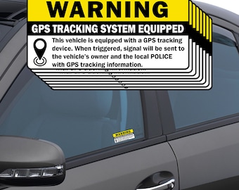 May include: A black car window with a yellow and black warning sticker. The sticker reads "WARNING GPS TRACKING SYSTEM EQUIPPED" and includes a description of the GPS tracking device.