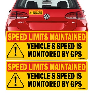 May include: Two yellow and red warning signs with black text that reads "Speed Limits Maintained Vehicle's Speed Is Monitored By GPS" and a black exclamation point inside a yellow triangle. The text "© TOTOMO" is at the bottom of each sign.