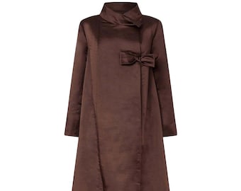 Op de afbeelding: Een lange bruine jas met een hoge kraag en een strikdetail op de taille.