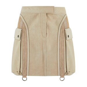 May include: A beige suede mini skirt with mesh panels and two large cargo pockets on the sides. The skirt has adjustable straps with silver rings.
