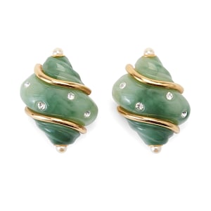 May include: A pair of green and gold earrings. Each earring has a swirling, shell-like design with gold-colored metal accents. Small, clear crystals are embedded in the green material, and a small pearl sits at the top and bottom of each earring.