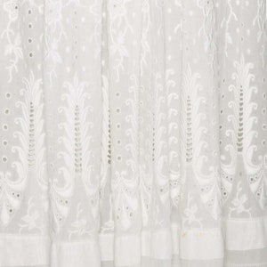 May include: White cotton fabric with a delicate embroidered pattern of leaves and flowers. The fabric has a sheer, airy quality and is perfect for a summer dress or blouse.