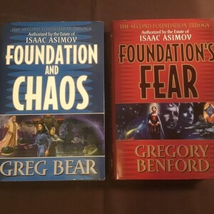 May include: Two paperback books, both part of the "Second Foundation Trilogy" series. The book on the left is blue with the title "Foundation and Chaos" by Greg Bear. The book on the right is red with the title "Foundation's Fear" by Gregory Benford.