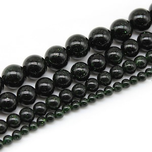 May include: A strand of dark green beads with a speckled texture. The beads are round and come in various sizes.