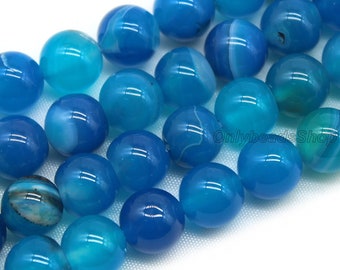 May include: A strand of round, blue agate beads with white and gray marbling. The beads are approximately 10mm in diameter.