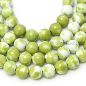 May include: A strand of green and white jade beads. The beads are round and have a mottled pattern.