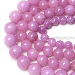 Puede incluir: Una hebra de cuentas redondas de piedras preciosas de color lavanda. Las cuentas son lisas y pulidas, con un ligero brillo. Las cuentas est&aacute;n enhebradas en un hilo transparente.