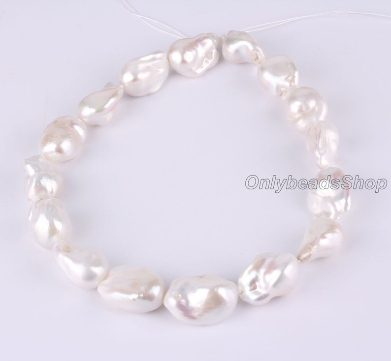 Peut inclure: Un collier de perles baroques blanches enfil&eacute;es sur un fil blanc. Les perles sont de forme irr&eacute;guli&egrave;re et ont une finition lisse et brillante.