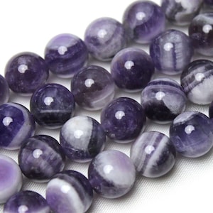 May include: A strand of round, purple and white striped amethyst beads. The beads are smooth and polished.