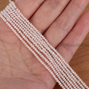 May include: A strand of white freshwater pearls, approximately 2mm in size, strung on a thin thread. The pearls are uniform in shape and size, and have a smooth, lustrous finish.