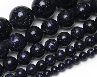 May include: A strand of dark blue gemstone beads with a speckled texture. The beads are round and vary in size, creating a graduated effect.