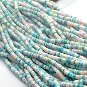 May include: Strands of colorful, flat beads in pastel shades of pink, blue, green, and yellow. The beads are strung together, creating a textured and visually appealing pattern. The beads are small and round, perfect for jewelry making.