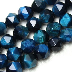 May include: A strand of blue and green faceted gemstone beads. The beads are round and have a multi-faceted, starburst-like appearance.
