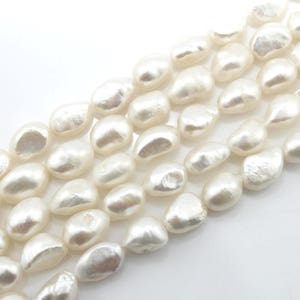 May include: A strand of white baroque freshwater pearls. The pearls are irregular in shape and have a smooth, lustrous finish.