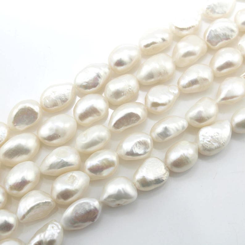 May include: A strand of white baroque freshwater pearls. The pearls are irregular in shape and have a smooth, lustrous finish.