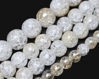 Può includere: Una collana di perle di cristallo trasparenti e marrone chiaro. Le perle sono rotonde e hanno una superficie testurizzata e con bolle.