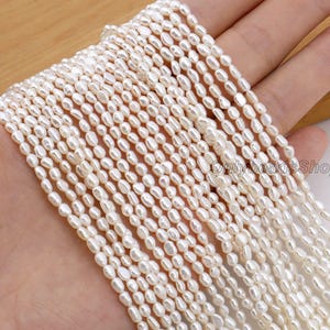 May include: Multiple strands of white, oval-shaped pearls. The pearls are strung together, forming several lines of the same beads. The pearls are a creamy white colour and have a smooth, lustrous surface. The image is of a jewellery supply.