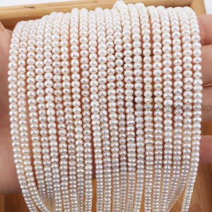 May include: Close-up of multiple strands of small, white pearls. The pearls are strung together, creating a dense, textured surface. The pearls are a creamy white color and appear to be uniform in size and shape. The image is well-lit, highlighting the luster of the pearls.