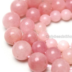May include: A strand of pink rose quartz beads. The beads are round and smooth, and they have a natural, polished finish. The beads are strung on a clear elastic cord.