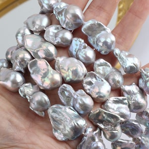 May include: A strand of baroque freshwater pearls in a silvery grey colour with iridescent highlights. The pearls are irregular in shape and have a natural, organic look.