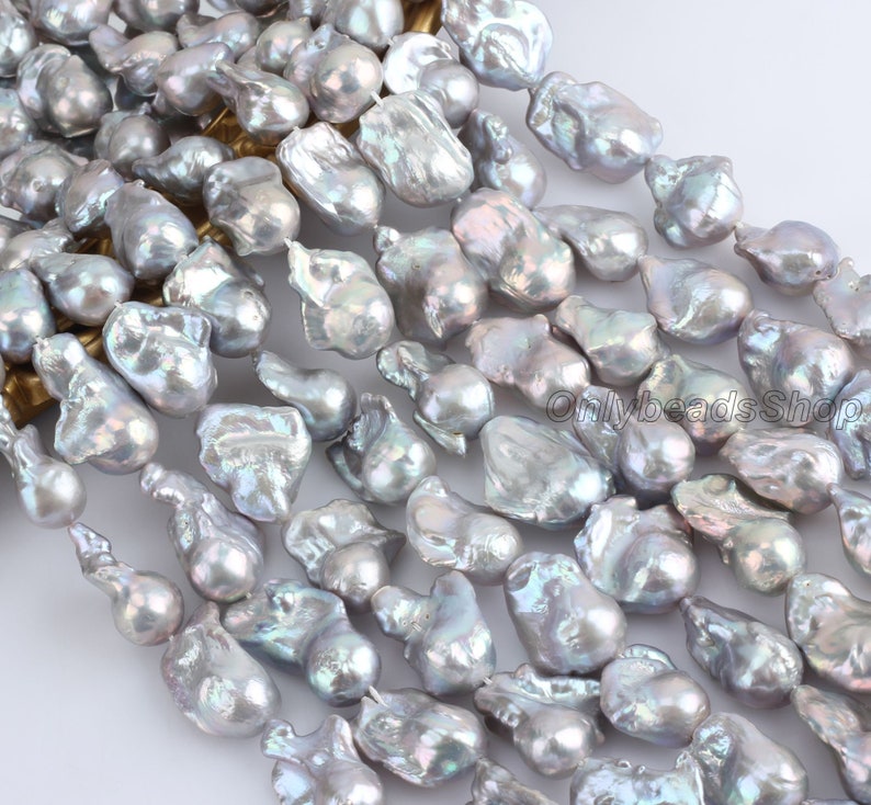 May include: A strand of baroque freshwater pearls in a silvery grey colour with iridescent highlights. The pearls are irregular in shape and size, with some being teardrop-shaped and others being more rounded.