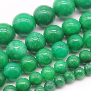 May include: A strand of round, green jade beads. The beads are smooth and polished, with a slight variation in color and texture.