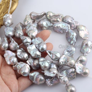 May include: A strand of baroque freshwater pearls in shades of grey and lavender. The pearls are irregular in shape and have a high lustre.