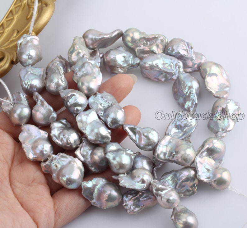 May include: A strand of baroque freshwater pearls in shades of grey and lavender. The pearls are irregular in shape and have a high lustre.