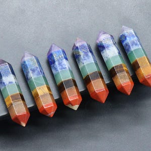 May include: Seven chakra crystal wands, each with a different color and pattern. The wands are made of natural stones and are believed to promote healing and balance.