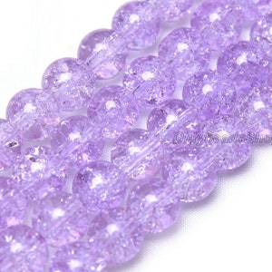 May include: A strand of lavender glass beads with a textured, crackled finish. The beads are round and have a translucent appearance.