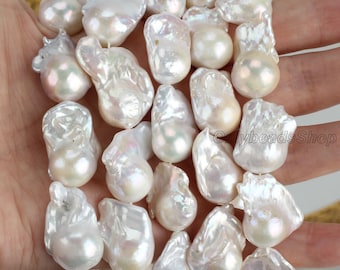May include: A strand of white baroque pearls, each pearl is irregular in shape and has a high luster. The pearls are strung on a white cord and are approximately 10-12mm in size.