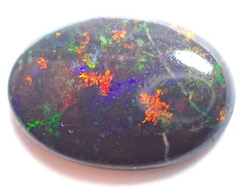 May include: A black opal gemstone with iridescent flashes of green, blue, and orange.