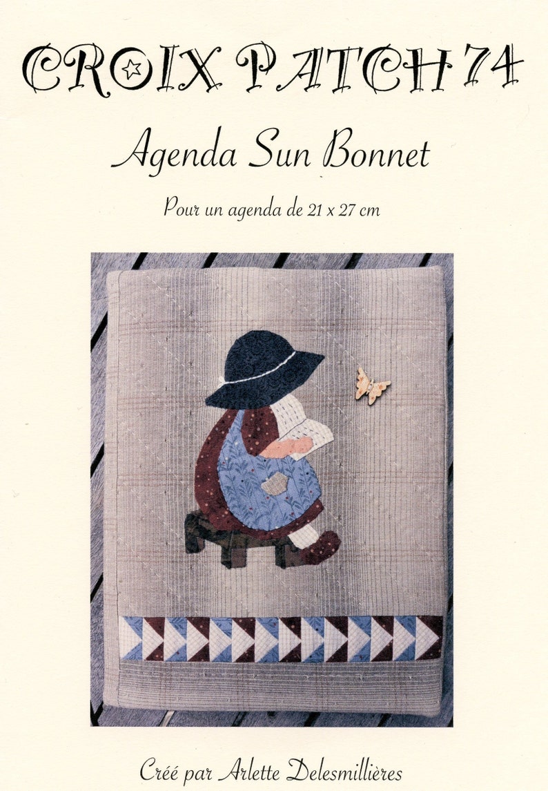 K&ouml;nnte beinhalten: Ein Stoffkunstmuster mit dem Titel "CROIX PATCH 74 Agenda Sun Bonnet". Das Cover zeigt ein Patchwork-Design eines M&auml;dchens mit Sonnenhut beim Lesen, mit einem Schmetterlingsakzent. Das Muster ist f&uuml;r ein 21 x 27 cm Agenda.