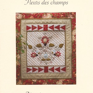 Peut inclure: Une pièce textile matelassée avec le texte "CROIX PATCH 74" et "Fleurs des champs". Le motif central présente des fleurs brodées en rouge, bleu et beige. Dimensions : 62 x 55 cm.