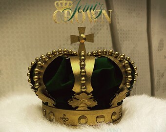 May include: A gold crown with a green velvet lining and gold accents. The crown has a cross on top and the words "Jeiniz Crown" are written above it.