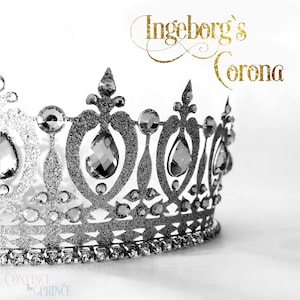 Może przedstawiać: Srebrna korona z brokatem z przezroczystymi cyrkoniami i napisem "Ingeborg's Corona" złotymi literami.